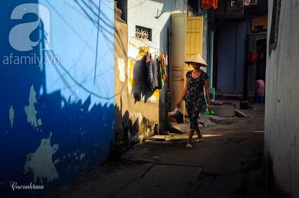 Một phụ nữ đi chợ về trên con ngõ vắng.