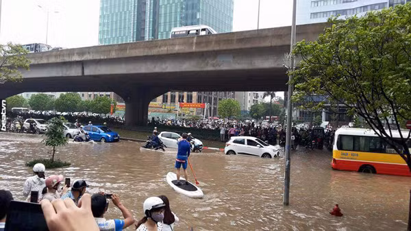 Anh chàng sử dụng một chiếc ván bơm hơi kèm mái chèo để di chuyển trên phố tràn ngập nước, trên tay còn cầm tờ giấy ghi dòng chữ "thuyền ôm" khiến nhiều người bật cười.