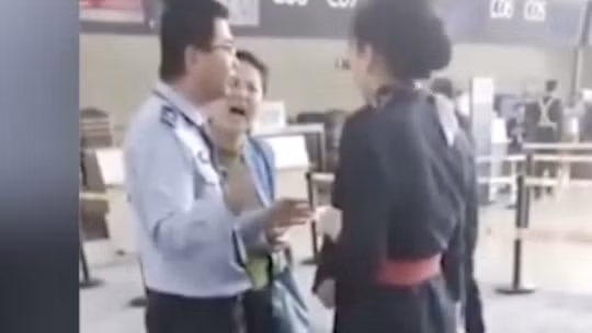 Một người phụ nữ Trung Quốc, được cho là giảng viên đại học, đe dọa đánh nhân viên hàng không sau khi bị từ chối lên máy bay vì đến trễ. Ảnh: SCMP