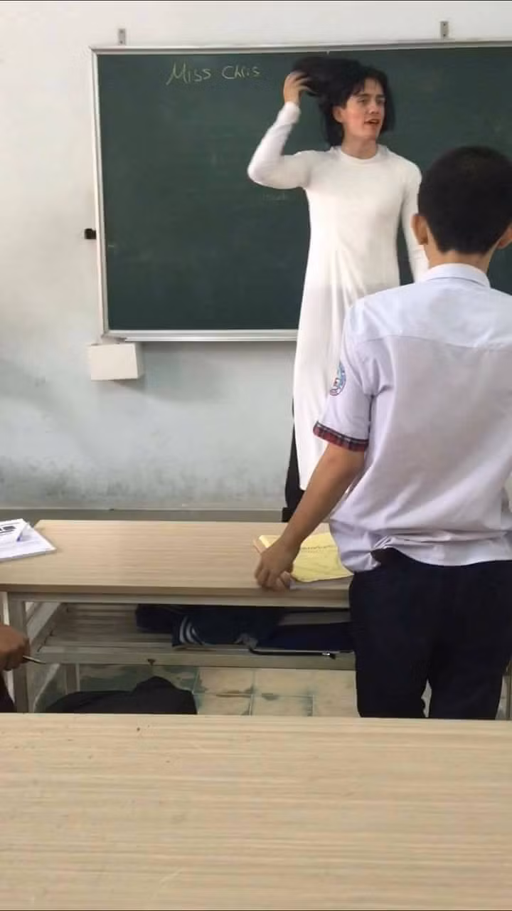 Cụ thể là chẳng biết lấy từ đâu ra và chuẩn bị từ bao giờ, thầy giáo ngoại quốc có riêng một bộ áo dài vừa vặn với mình, một bộ tóc giả hơi rũ rượi và hóa thân thành một "cô giáo phiên bản lỗi".