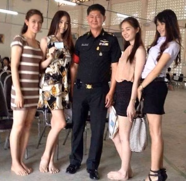 Dàn bóng hồng chuyển giới vây quanh chụp ảnh chung với tuyển trạch viên của quân đôi Thái Lan.
