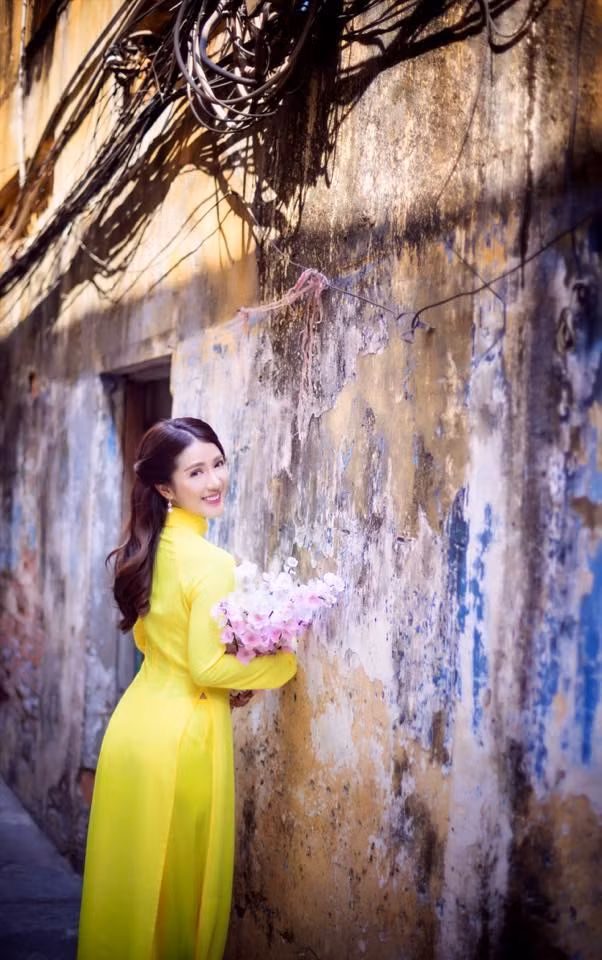 Trong nắng vàng rượm, lại càng tôn lên vẻ đẹp của chiếc áo dài vàng mà Linh Napie đã lựa chọn.