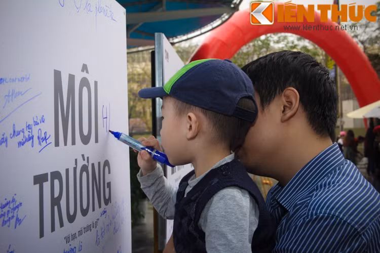 Một em bé chung tay viết lên tấm bảng kỉ niệm của chương trình.