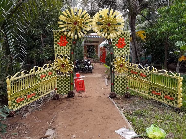Ngắm nhìn những chiếc cổng cưới tết bằng lá dừa, tuy có phần đơn sơ dân dã, nhưng thấm đượm tình làng nghĩa xóm bởi nó là công sức và thành quả lao động miệt mài của hàng xóm cũng như họ hàng để mừng cưới đôi tân hôn.