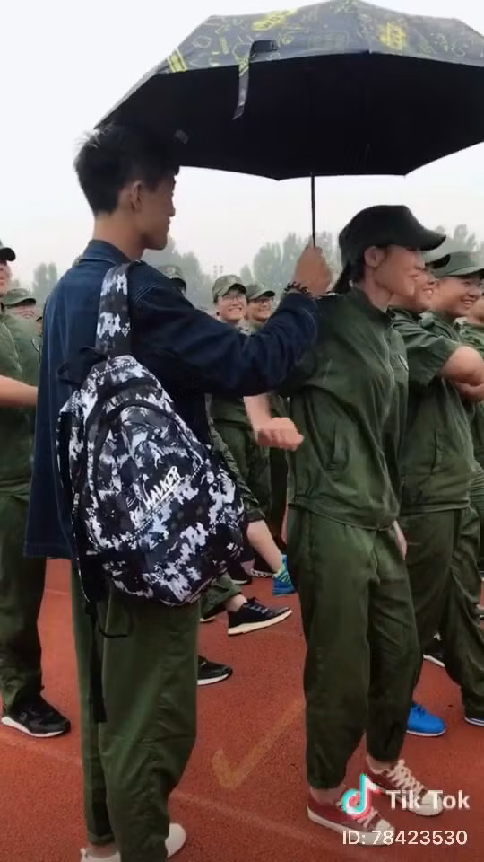 Bỏ qua những ánh mắt những người bạn đứng xung quanh, chàng nam sinh xuất hiện trong clip vẫn kiên trì làm hành động che ô cho bạn gái đang đứng trong hàng ngũ.