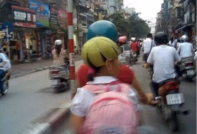 Hình ảnh em bé đội vỏ bưởi thay mũ bảo hiểm ngồi sau xe mẹ cũng từng gây sốt cộng đồng mạng Việt.