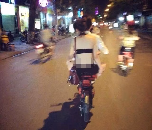Hình ảnh cô gái trẻ ăn mặc thoáng mát đi xe đạp điện cùng bạn trai xuống phố. Nhìn phần trên mọi người nghĩ ngay tới việc, cô ta chỉ mặc áo lót ra đường.