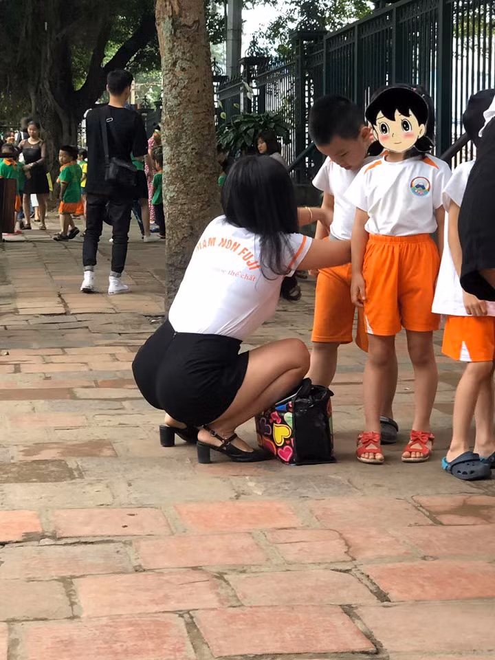 Xuất hiện vô cùng đơn giản, không màu mè với bộ quần áo đồng phục của trường, cô giáo mầm non vẫn khoe được hết nét đẹp của mình.