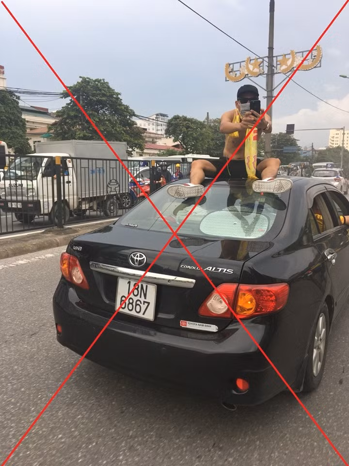Hình ảnh ngồi lên nóc ô tô di chuyển diễu hành của CĐV Nam Định trên đường phố Hà Nội.