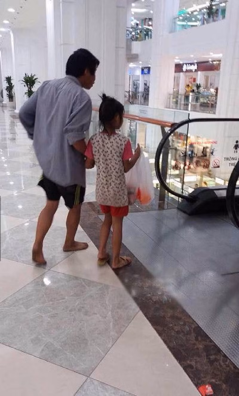 Người ta sang chảnh vào trung tâm siêu thị nhưng người cha nghèo thể hiện rõ bản thân cùng đứa con gái nhỏ.