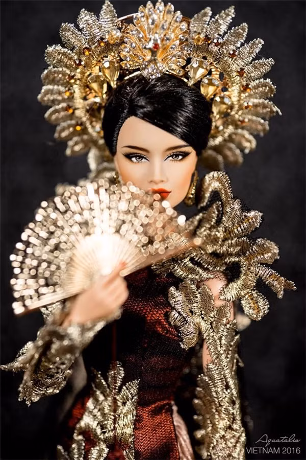 Chiếc áo dài của đại diện Việt Nam tại Hoa hậu Búp bê Thế giới 2016 có tên gọi “Khổng tước vọng nguyệt”, lấy ý tưởng từ vẻ đẹp của chim công soi mình dưới ánh trăng vàng.