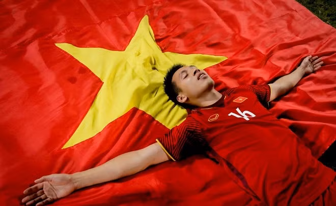Hùng Dũng nằm trên lá cờ tổ quốc ngập chìm trong niềm vui chiến thắng.