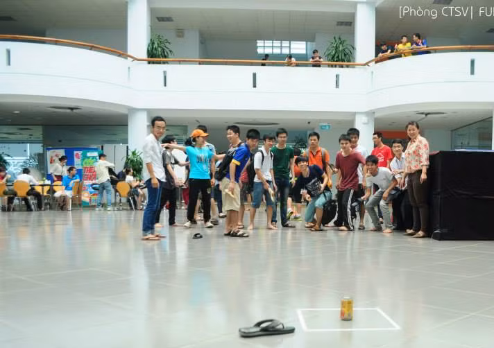 Nhiều bạn sinh viên cũng tranh thủ trước giờ học của mình làm ván "tạt lon" ngay tại sảnh của giảng đường. Ảnh: Facebook.