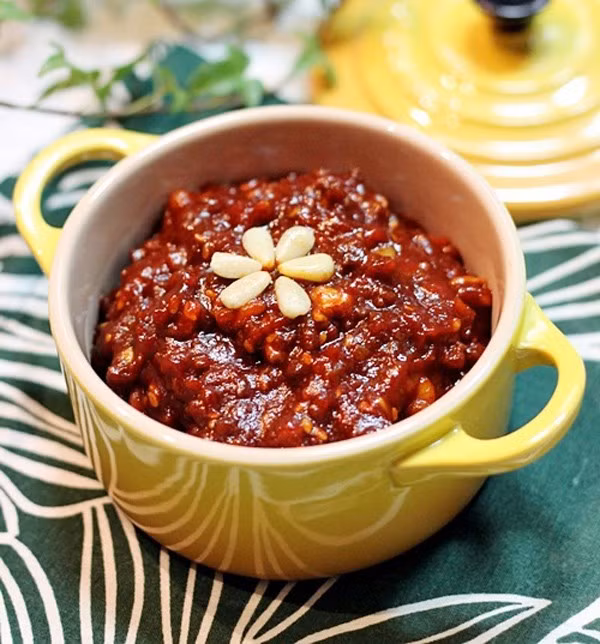 Cho thịt bò xào trong 1 phút rồi cho tương ớt vào xào, thêm nước ép hành tây đun sôi trên lửa vừa trong 5 phút. Tiếp theo, cho óc chó, hướng dương, hạnh nhân, hạt bí ngô cắt nhỏ vào đảo đều khoảng 2 phút. Thêm hạt mè vào trộn đều. Cuối cùng, cho dầu mè và mật ong trộn đều đun thêm 2 phút rồi tắt bếp. Ảnh: Dulichhanquoc.