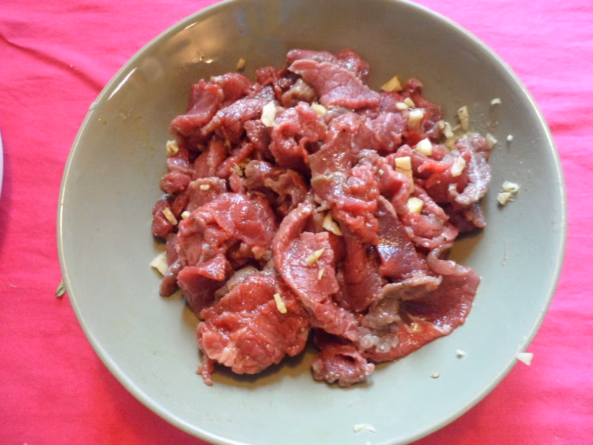 3. Thịt trâu xào mỡ hành. Nguyên liệu: Thịt trâu, hành lá, hành tím, ớt, tỏi, lá lốt, chanh, gia vị: muối hột, bột ngọt, dầu ăn. Thịt thái miếng vừa ăn, ướp thịt với gia vị 15 phút. Ảnh: VietQ.