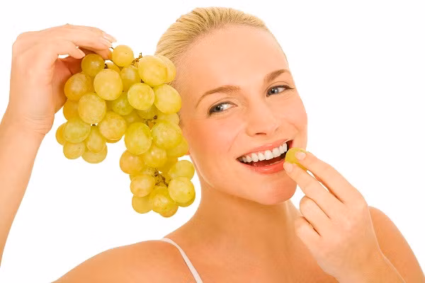 Nghiền nát 10 trái nho chín đã tách hạt trộn đều với 2 thìa bột bắp, 2 thìa mật ong được 1 hỗn hợp sền sệt, thoa hỗn hợp này lên mặt, thư giãn khoảng 15 phút rồi rửa lại bằng nước sạch. Ảnh: Ladorax.com.