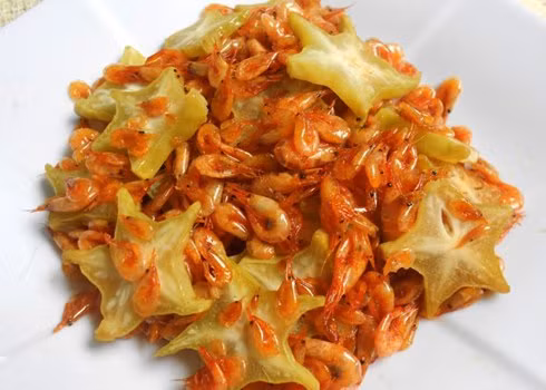 Khế chua gọt bỏ diềm, thái lát mỏng chừng 0,5 cm. Cho dầu ăn vào chảo, phi thơm hành và tỏi, cho tép vào rang khoảng 5 phút thì bạn cho khế vào. Nêm vào đó một chút nước mắm. Đảo tép đều tay sau đó cho vào tép 1 thìa cà phê đường, rang thêm khoảng 1-2 phút thì cho hành lá vào và tắt bếp. Ảnh: 7monngonmoingay.net.
