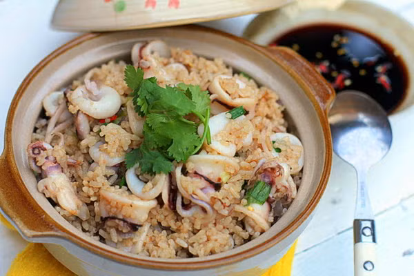 Thái nhỏ hành tây, hành lá, tỏi và ớt. Làm nóng chảo và xào phần hành tây đến khi dậy mùi thơm lại tiếp tục cho tỏi vào. Khi tỏi đã vàng cạnh, bạn cho phần trứng mực và mực vào đảo đều. Mực chín, cho phần cơm vào rang đều tay và nêm nếm lại gia vị cho vừa miệng. Khi chuẩn bị tắt bếp bạn cho phần hành lá vào đảo đều. Ảnh: phunubeo.vn.