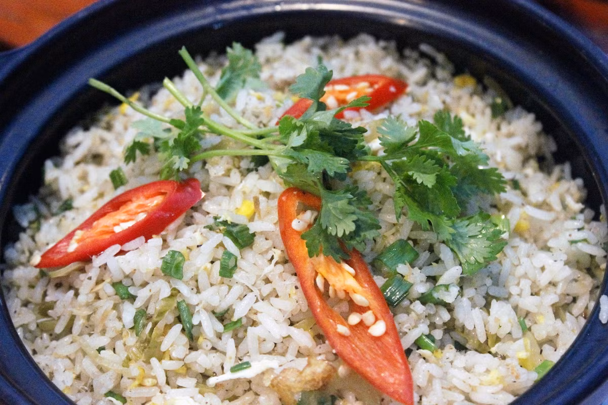 Vẫn cái chảo ấy, cho thêm 1 thìa dầu ăn vào, đun nóng rồi cho tô cơm vào xào cho đến khi hạt cơm săn lại. Cho bắp cải vào xào cho chín. Tiếp đến bạn cho cá mặn, hành lá vào và nêm lại gia vị cho vừa ăn rồi rắc chút tiêu lên xúc cơm ra đĩa và thưởng thức. Ảnh: 123zo.vn.