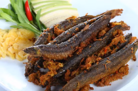 Đặt chảo lên bếp, chờ dầu sôi, cho chạch vào chiên nhỏ lửa để chạch chín vàng đều và giòn. Khi chiên, lưu ý bỏ bớt phần riềng sả... bám vào cá. Cá chín thì cho phần này vào chảo chiên cùng, đảo đều để chúng bám vào cá, khi ăn cùng rất ngon. Ảnh: homnayangi.vn.