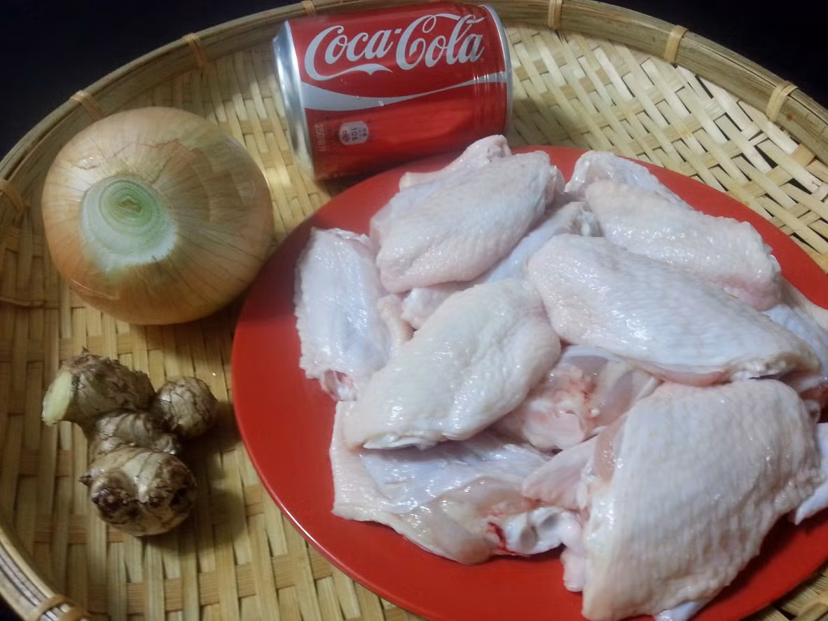 1. Cánh gà rim Coca Cola. Nguyên liệu: Cánh gà, hành lá, nước tương, tương ớt, gừng, Coca Cola, hạt nêm, dầu ăn. Gừng cạo vỏ, rửa sạch, cắt lát to. Hành lá rửa sạch, cắt khúc dài. Làm nóng dầu ăn, cho gừng và hành lá vào phi thơm. Trút gà vào, đảo nhanh tay với lửa vừa. Nêm hạt nêm và nước tương. Sau khi xào gà khoảng 3 phút, cho Coca Cola vào là được. Ảnh: kenhphunu.com.