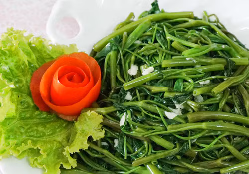 Phi thơm tỏi, khi tỏi bắt đầu có mùi thơm và ngả vàng, bạn cho rau muống đã chuẩn bị vào chảo, tiếp tục dùng đũa đảo, sau đó nêm gia vị nước mắm, bột nêm, bột ngọt, đường cho vừa ăn. Lưu ý cần xào với lửa to, đảo đều tay và tắt bếp khi rau vừa chín tới. Ảnh: eva.vn.