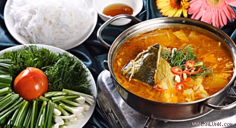 Cho bạc hà, giá, cà chua, đậu bắp, bắp cải, măng tươi rồi nêm chút đường. Nồi cá sôi lần nữa, múc ra tô, rắc rau ngò om xắt nhỏ với mấy lát ớt sừng. Ăn kèm với lẩu cá nhám giàu canh chua sả nghệ cũng có thể là đĩa bún trắng tươi, đĩa rau muống và nước mắm trong. Ảnh: xaluan.com.