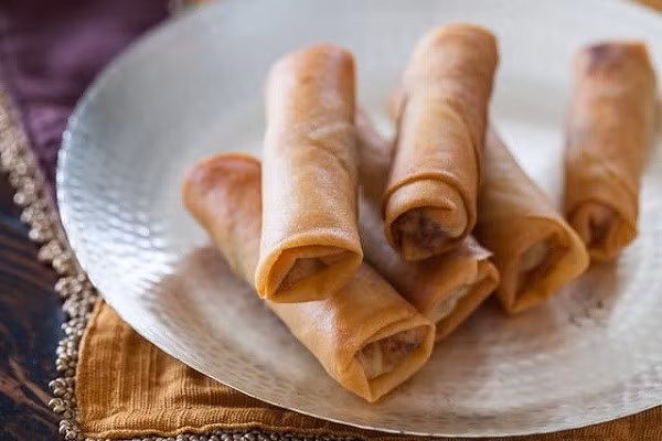 Nướng bánh ở 190 độ C khoảng 15-20 phút hoặc khi thấy vỏ bánh bắt đầu chuyển sang màu vàng nâu thì lấy khay nướng ra khỏi lò. Dùng cọ phết 1 lớp bơ mỏng lên từng cái bánh và rắc bột đường quế lên trên. Tiếp tục nướng trong vòng 5 phút nữa là hoàn thành rồi. Ảnh: baomoi.com.