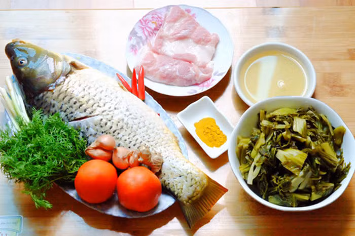 Cá chép om dưa. Chuẩn bị 1 con cá chép, thịt ba chỉ, dưa muối, cà chua, hành, nghệ, thì là, ớt. Cá chép đánh vẩy, mổ bụng, làm sạch. Khứa vào đường trên bề mặt cá. Sát ít muối vào trong phần bụng cá đã rửa sạch, thấm khô. Có thể cho cá vào chảo rán vàng da. Ảnh: Toinayangi.