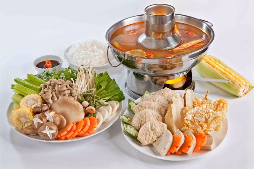 Cho nước dừa tươi vào nồi cùng 1 trái thơm và sả cây đập dập. Tiếp theo cho boa rô cắt khúc và 1 trái bắp cắt khúc vào nồi nước dùng. Cho 2 gói gia vị chua và cay vào nồi nước dùng. Nước dùng sôi, nêm lại cho vừa ăn. Khi ăn múc nước dùng ra nồi nhỏ, cho nấm rơm vào nồi nước dùng cùng cà chua và ngò gai cắt khúc nhỏ. Bày ra rồi trang trí. Ảnh: cachnauan.edu.vn.