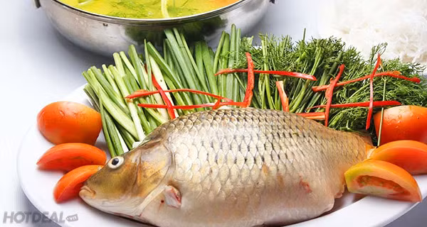 2. Lẩu cá. Nguyên liệu: Cá trắm hoặc chép, thịt bò, ngao, dạ dày, lòng non, đậu phụ, cà chua, me chua, rau diếp, rau cải, rau cần, hành, răm, thìa là, gừng, ớt, chanh, súp, mỳ. Ảnh: Hotdeal.vn.
