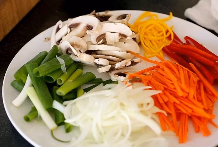 3. Miến xào kiểu Hàn. Nguyên liệu gồm miến Hàn Quốc, hành tây, cà rốt, cải xoăn, hành lá, tỏi, nấm đông cô, thịt bò, vừng rang, nước tương, dầu mè, dầu ăn, đường, hạt nêm. Đầu tiên luộc sơ qua miến và để ráo. Hòa chút dầu mè, nước tương, đường đánh tan rồi đổ vào miến ướp. Ảnh: Laodong.
