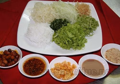 Da lợn cắt lát mỏng rồi chiên giòn. Nghêu luộc lấy phần nước trong, lấy thịt nghêu. Hến đem rửa sạch lại sau đó đem xào với tỏi, nêm gia vị: nước mắm, tiêu.Pha hỗn hợp: khoảng 3 muỗng mắm ruốc, 3 muỗng đường, 3 muỗng canh nước nghêu luộc để nêm nếm. Ảnh: banhhue.net.