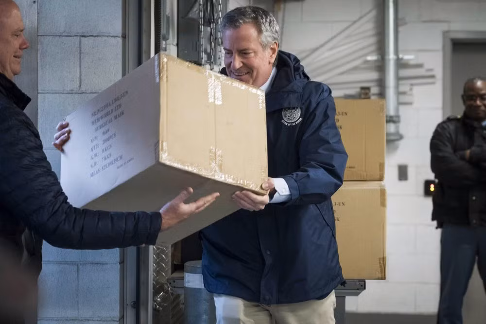 Thị trưởng thành phố New York Bill de Blasio giúp vận chuyển các thùng chứa 250.000 khẩu trang vào xe tải tại trụ sở chính của Liên Hợp Quốc tại Mỹ. Liên Hợp Quốc đã tặng thành phố New York khẩu trang để chống Covid-19. Ảnh: AP