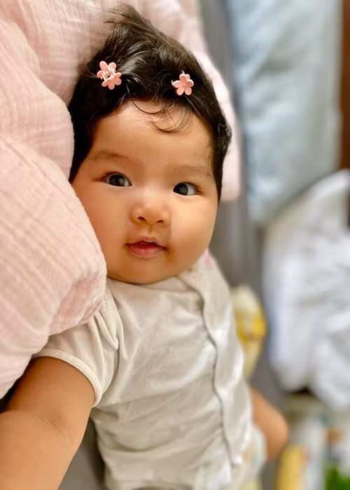 Lê Bê La kẹp lên mái tóc đen của bé Bình An những chiếc kẹp bông hoa nhỏ nhắn.