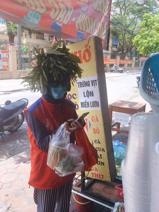 Nhìn từ xa thì hơi...buồn cười nhưng không thể phủ nhận công lớn của những chiếc lá này trong việc giúp shipper bớt nắng. Ảnh: Facebook
