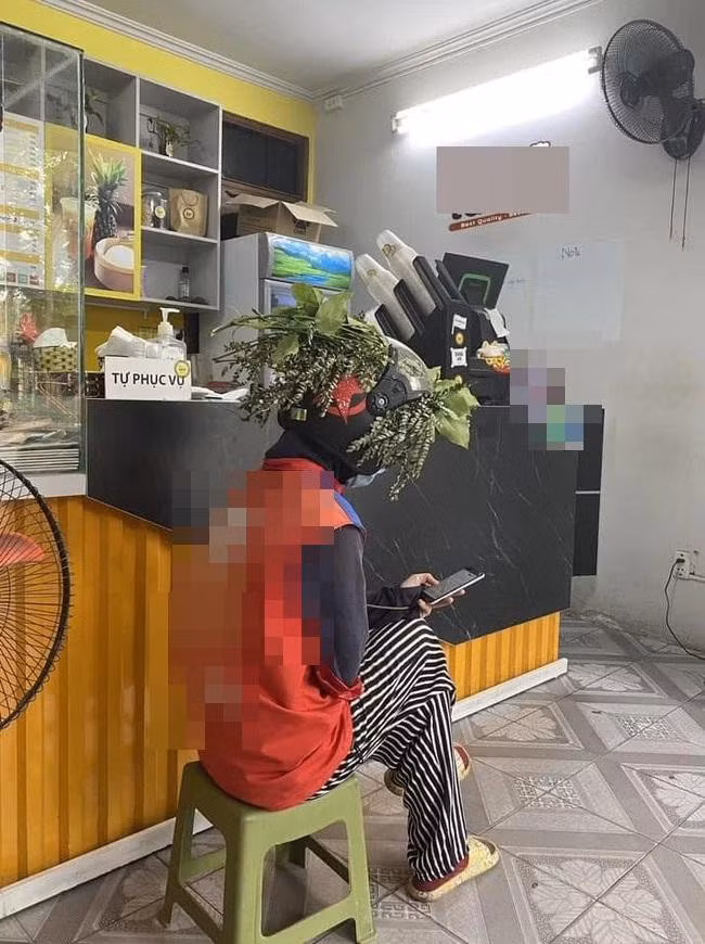 Anh chàng shipper này đã sử dụng nhiều lá cây rồi trùm lên đầu, lên tay lái xe máy để tránh nắng nóng dưới thời tiết như chảo lửa. Ảnh: Facebook