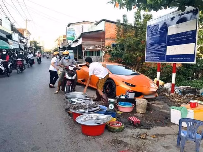 Một anh bán cá lề đường xỏ ủng nhìn khá "hai lúa", tuy nhiên chiếc siêu xe màu cam đỗ sau anh lại mới là điều khiến ai cũng "sốc".
