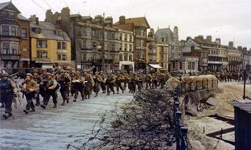 Binh sĩ thuộc Quân đội Mỹ hành quân qua một thị trấn của Anh hồi tháng 6/1944.