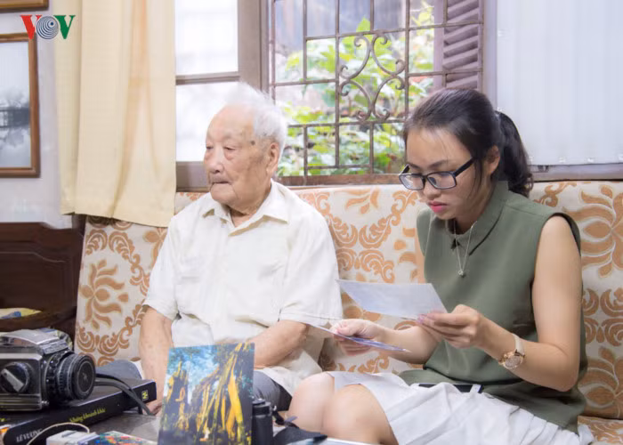 Một phóng viên trẻ chăm chú theo dõi những bức ảnh vô giá về Hà Nội xưa, những hình ảnh mà các thế hệ con cháu chỉ có thể mường tượng qua những tác phẩm của ông.