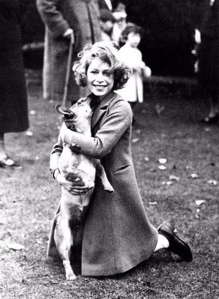 Nữ hoàng Elizabeth II tươi cười rạng rỡ bên chú cún cưng năm 1936. Nữ hoàng Anh là một trong những nhân vật quyền lực trên thế giới, góp phần làm thay đổi bánh xe lịch sử.