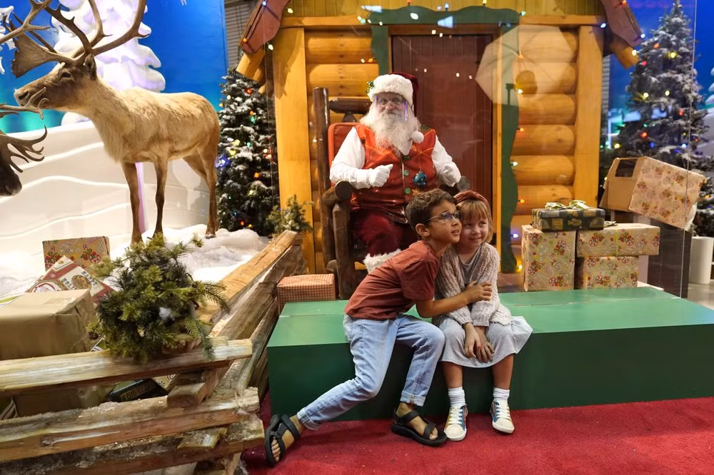 Để làm tốt nhiệm vụ, các ông già Noel đang tìm cách thích ứng với đại dịch. Một vài người đã tổ chức tương tác với trẻ nhỏ ở ngoài trời và không quên giữ khoảng cách, đeo khẩu trang. Ảnh: AP.