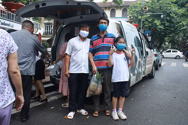 Một số người dân lưu lại những khoảnh khắc khi mua dứa, chụp chung 1 tấm ảnh với ông Đoàn Ngọc Hải.