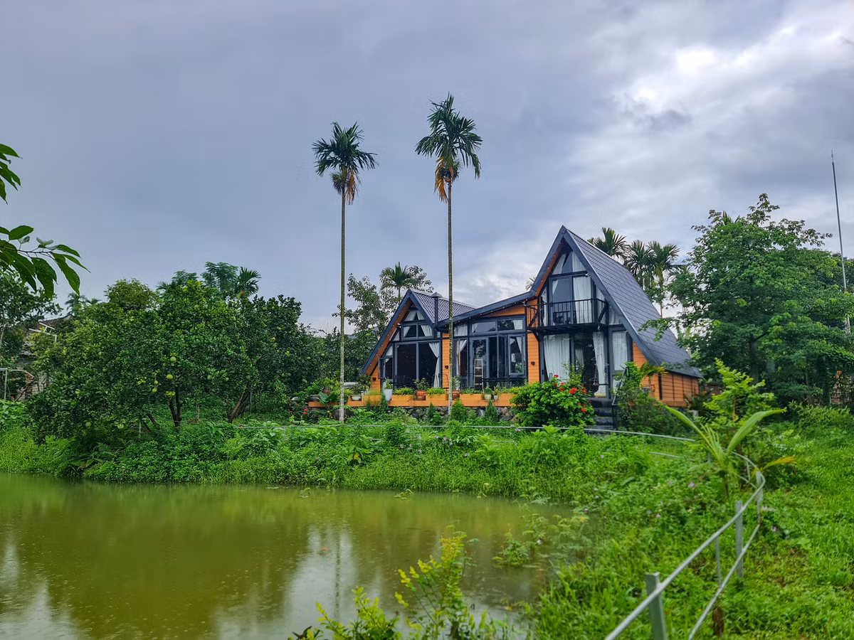 Toàn cảnh không gian nhà vườn tràn ngập sắc xanh của gia đình anh Sơn ở ngoại ô Hà Nội. Mong muốn cả gia đình có không gian sống xanh, tĩnh lặng và tách biệt khỏi sự ồn ào, khói bụi nơi thành phố nên cuối năm 2020, anh Sơn quyết định tìm mua một mảnh đất ở ngoại ô, dựng “ngôi nhà thứ hai” tràn ngập hương thơm và màu xanh của cỏ cây, hoa lá. Ảnh: Phan Hồng Sơn