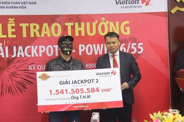 Ông T.H.M đeo mặt nạ kín mít nhận giải thưởng.