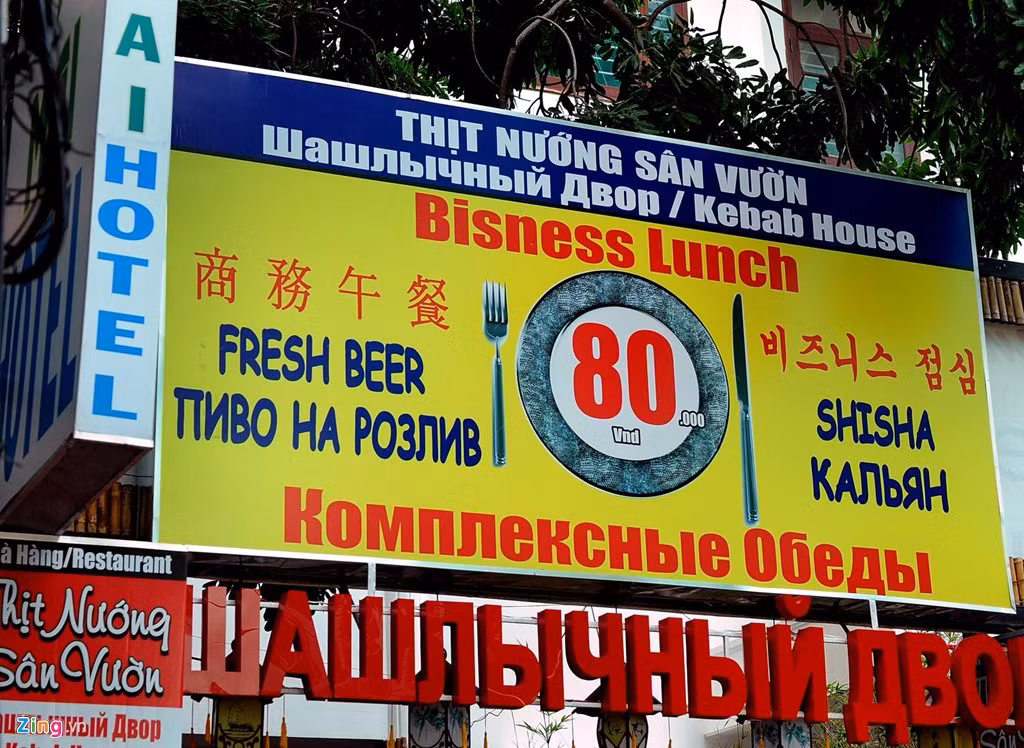 Một biển hiệu gồm cả tiếng Nga và tiếng Trung. Tiếng Việt lọt thỏm giữa rừng ngoại ngữ.