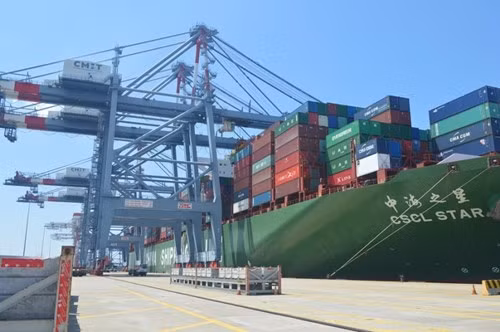 Hệ thống cẩu hàng từ xe container lên tàu hoạt động liện tục.