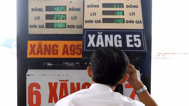 Người dân suy nghĩ trước khi chọn loại xăng nào tại một trạm xăng ở TP.HCM chiều 13-3. Ảnh: Hữu Khoa.