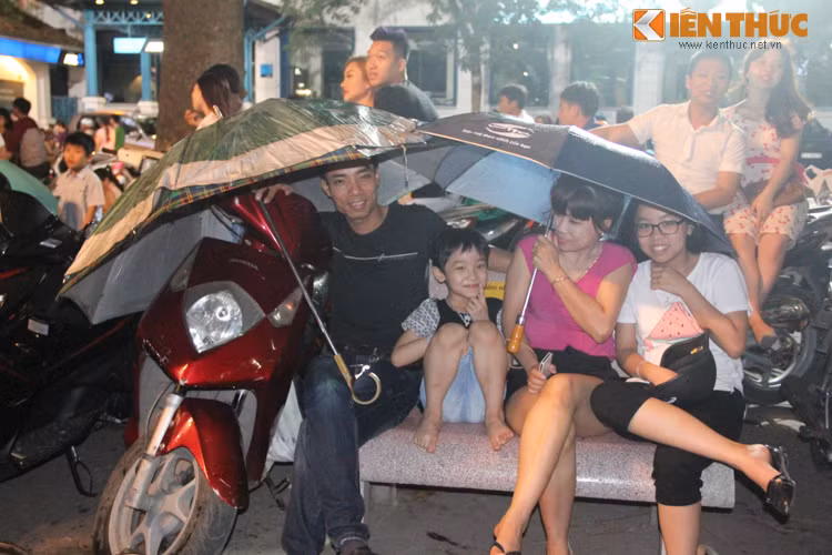 Người không có áo mưa thì che ô ngồi đợi.