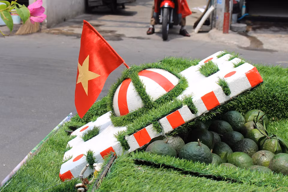 Ngay cả cái cân, bình phun nước, chiếc rổ cũng tươi mát một màu xanh. Chiếc nón đội trên đầu anh cũng sáng tạo và quyết “trồng cỏ phủ xanh”. Bên trong nón là chiếc mũ bảo hiểm, anh lấy thanh mút, bao phần nón và cắm bên trên lá cờ Tổ quốc. Vậy là có được chiếc nón độc, lạ.
